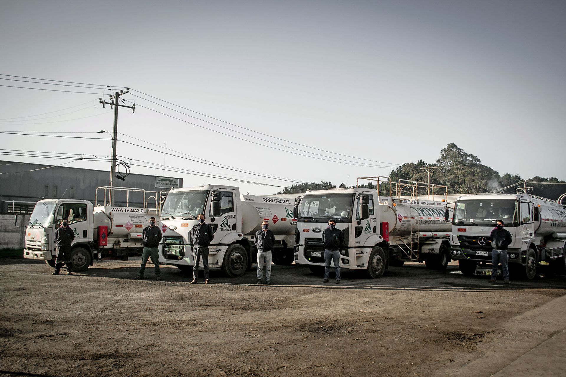 Flota de camiones TRIMAX junto a su equipo de operaciones