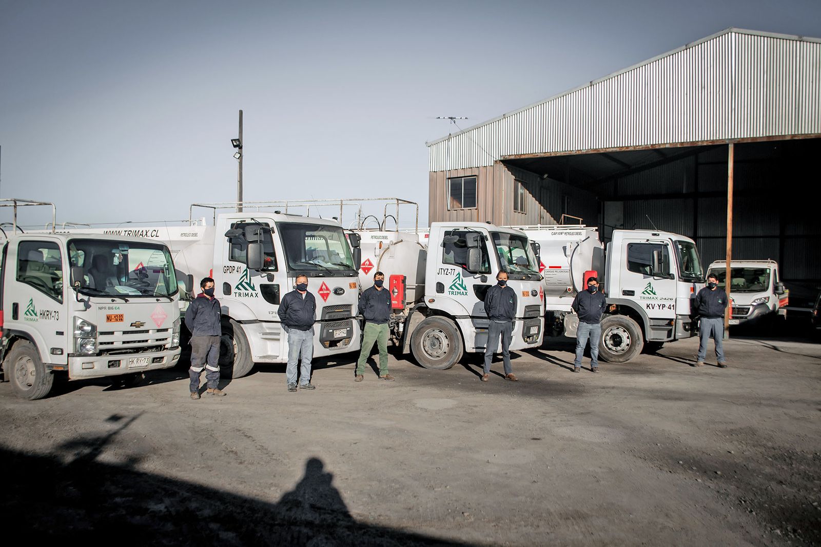 Camiones TRIMAX en patio de operaciones, listos para despacho